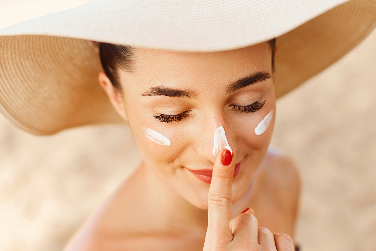 Beautiful Young Woman With Sun Cream On Face Girl Holding Sunscreen